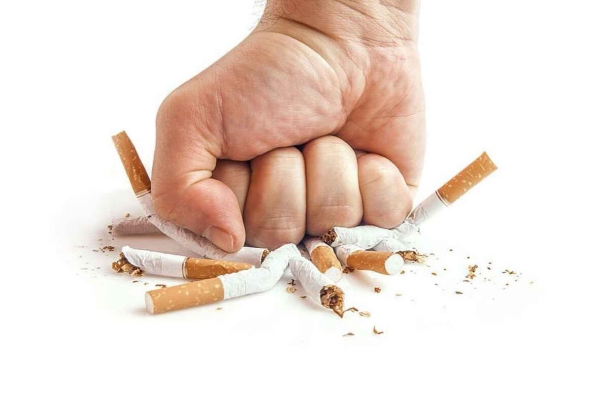 puño aplastando cigarros como símbolo de dejar de fumar